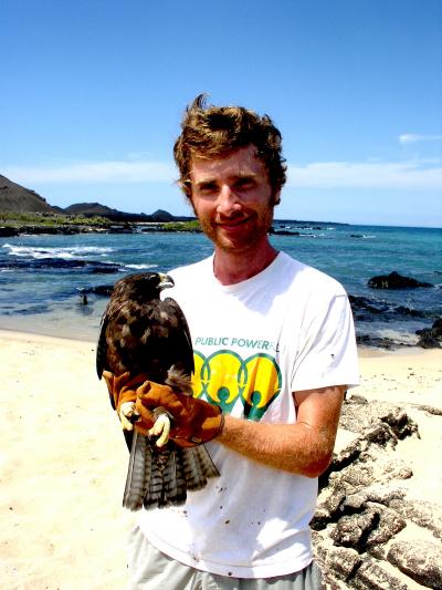 man holding a hawk on a beach